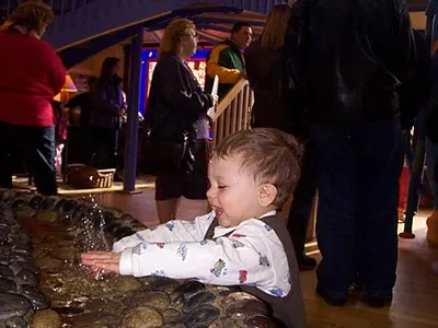 Owen splashing in a fountain.